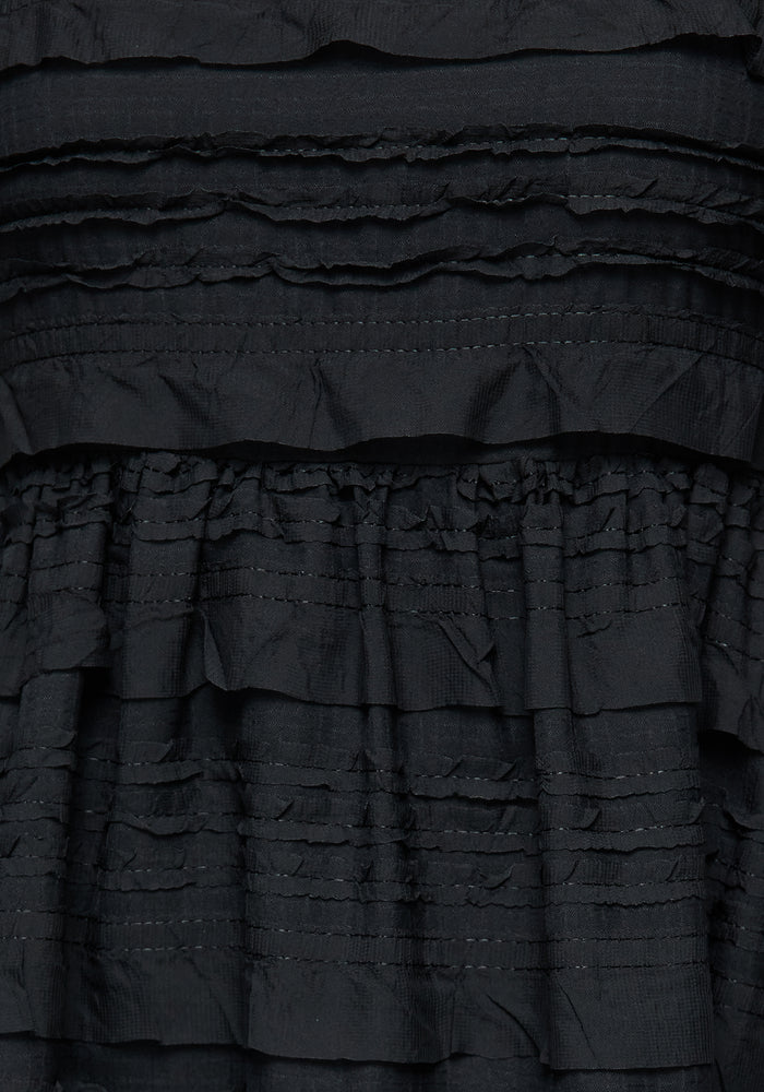 Detalle del tejido negro texturizado del vestido mini Initiation Babydoll.