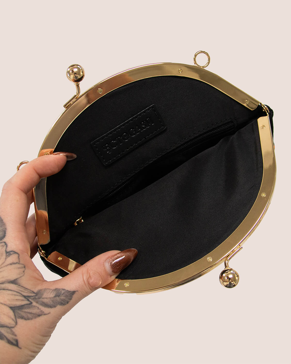 Bolso de terciopelo bordado con forma de calabaza en color negro.